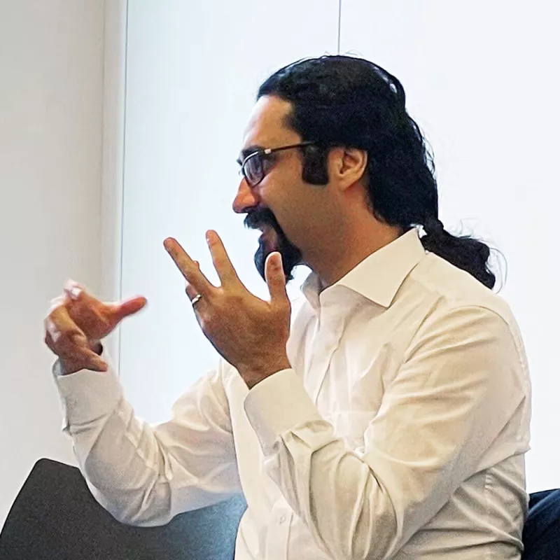 A man sits in the office and discusses gesticulating 