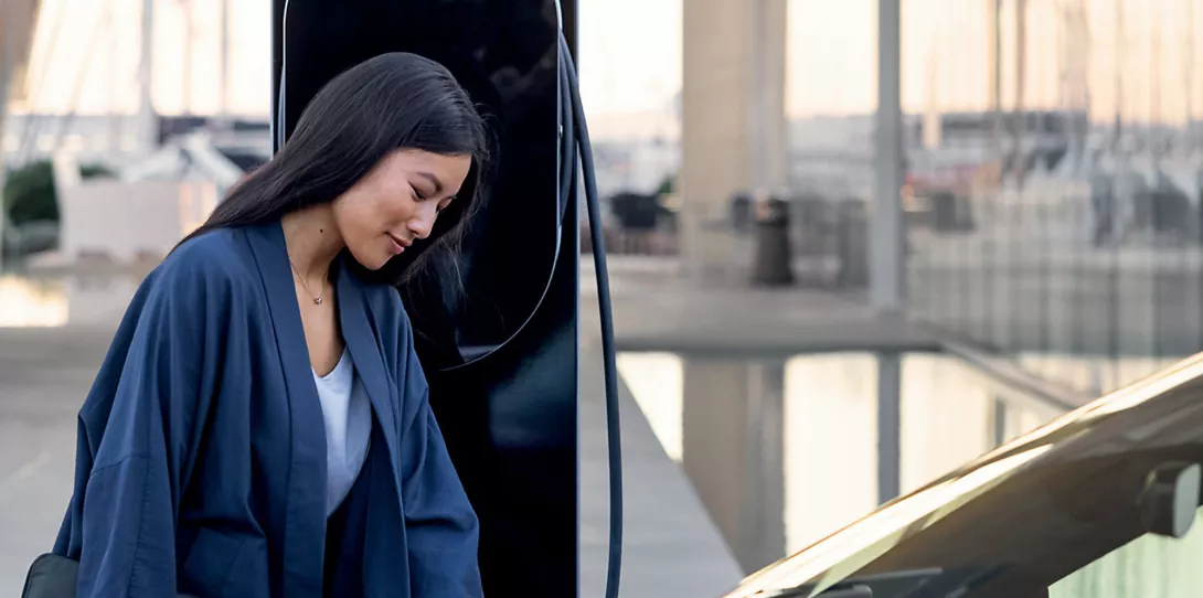 Woman in front of Porsche Charging the car at porsche electric power station