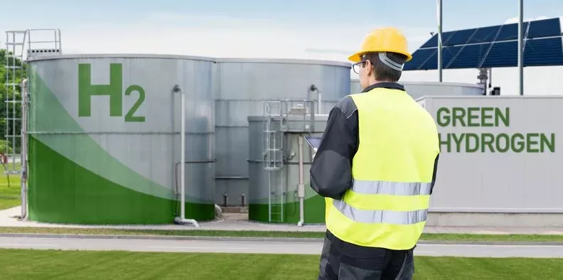 Mann Steht vor Anlage mit grünem H2, Vorprodukt von eFuels