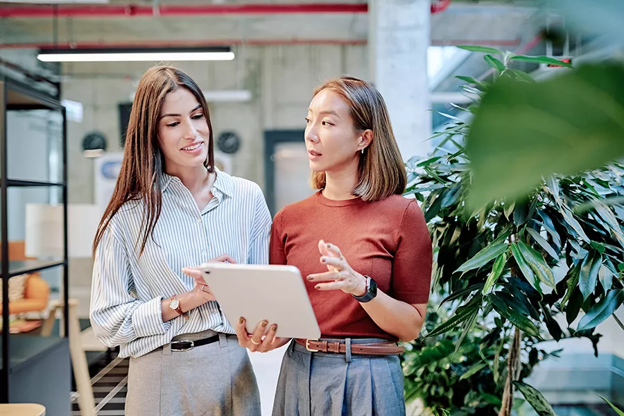 Sustainability Environment Women discussing on tablet 