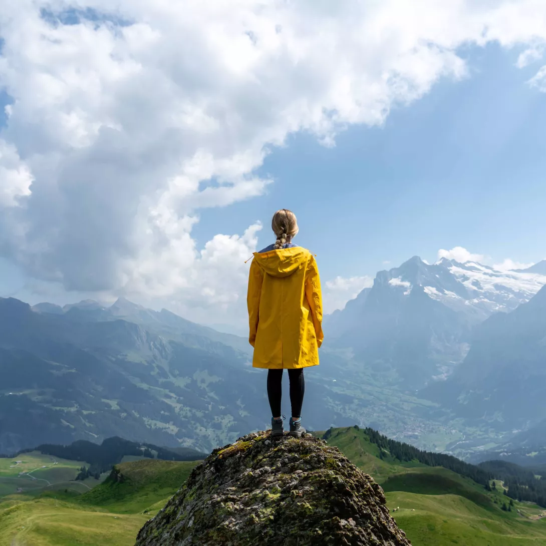 Woman standing on stone looking on mountains
