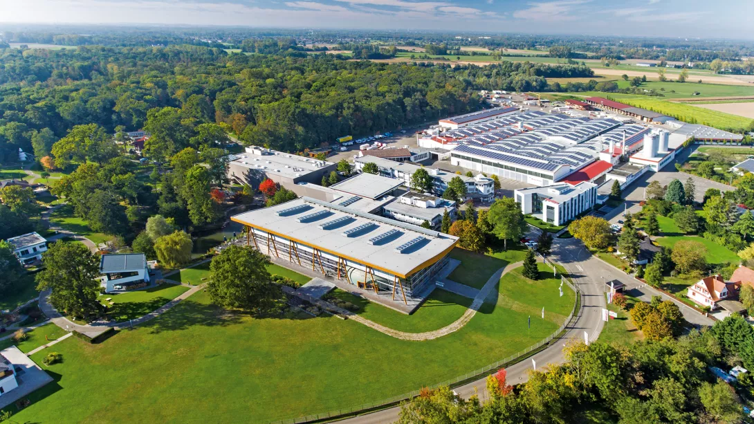 Blick auf den Stammsitz des Fertighausherstellers WeberHaus in Rheinau-​Linx. Gelegen in Baden-​Württemberg, unweit der französischen Grenze und der Stadt Straßburg, umfasst das Werksgelände neben den Produktions-​ und Bürogebäuden die imposante Erlebnis-​ und Musterhaus-​Ausstellung „World of Living“.