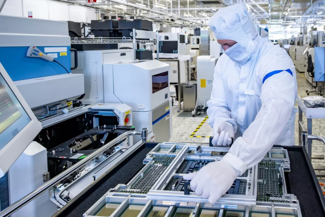 Ein Operator bestückt die Frontend Testanlage mit einem Loadboard bei Infineon