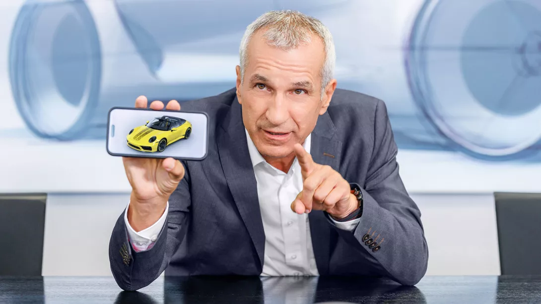 Albrecht Reimold Porsche AG mit Handy und Porsche