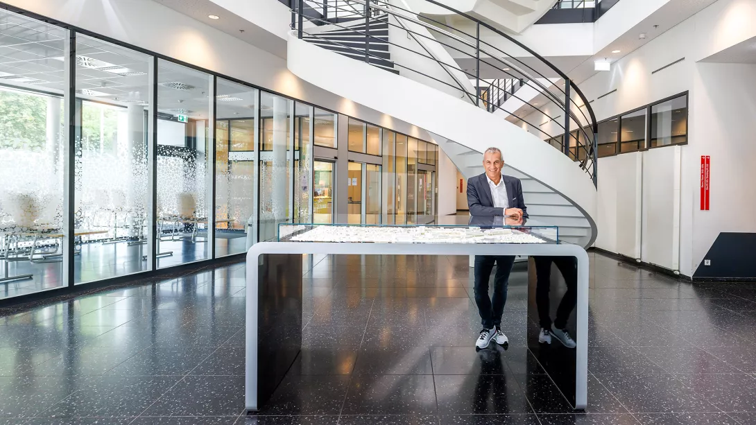 Albrecht Reimold Porsche AG im Firmengebäude vor Miniatur