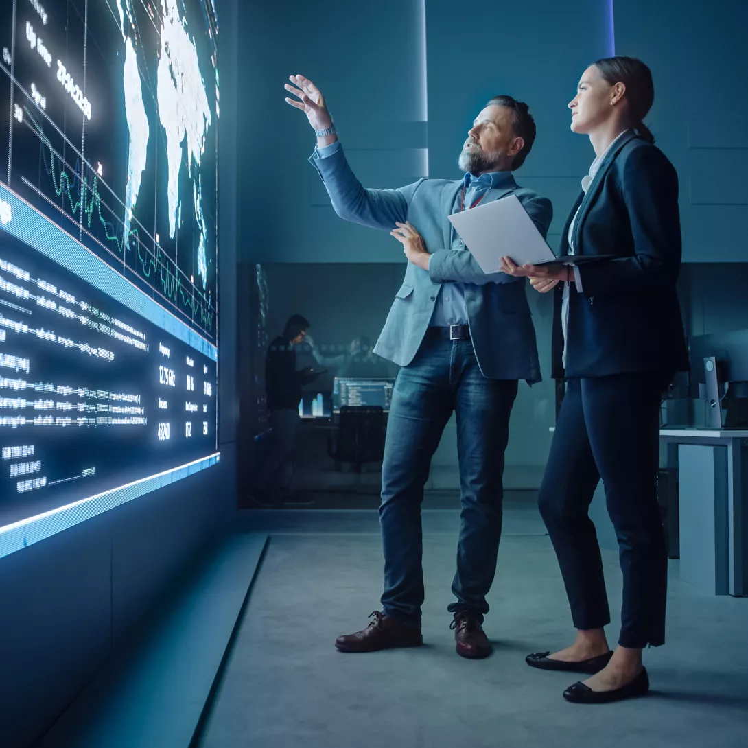 Man and Woman looking at digital world map defense 