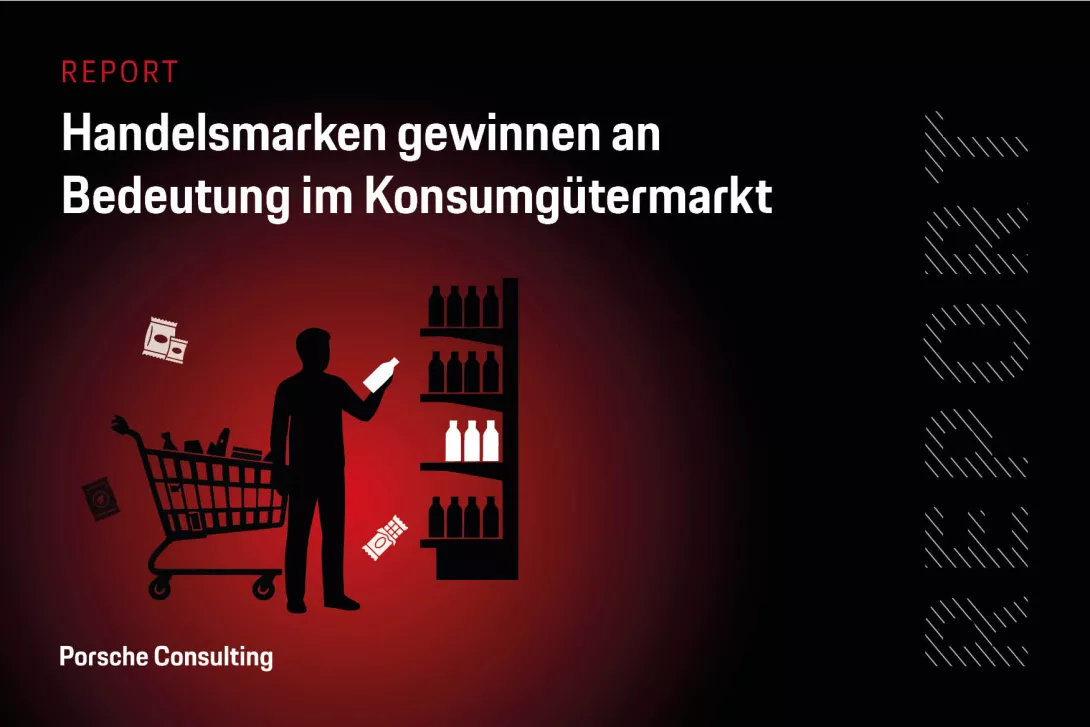 Eine Person steht neben einem Einkaufswagen und einem Supermarktregal und vergleicht verschiedene Produkte.